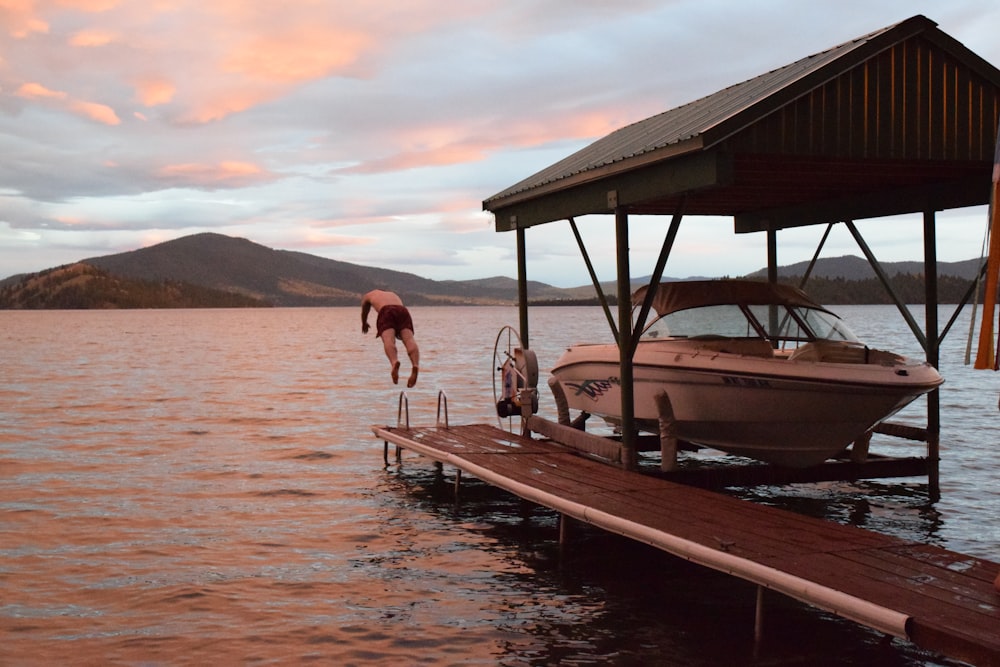 a man jumping off a dock into the water