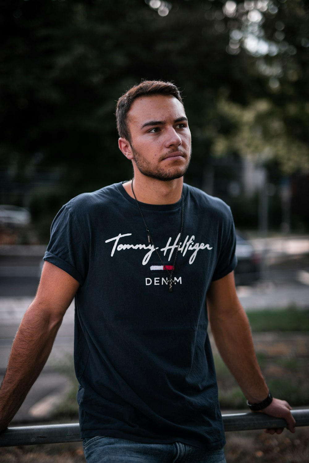 man in black crew neck t-shirt standing on road during daytime