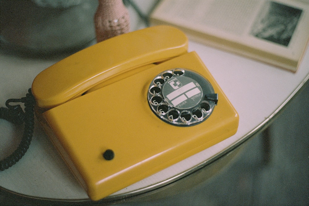 Teléfono de disco amarillo y plateado