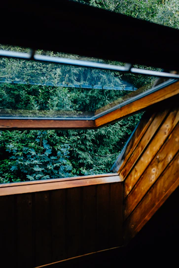 Bright and airy garden loft interior with natural wood accents and leafy views.