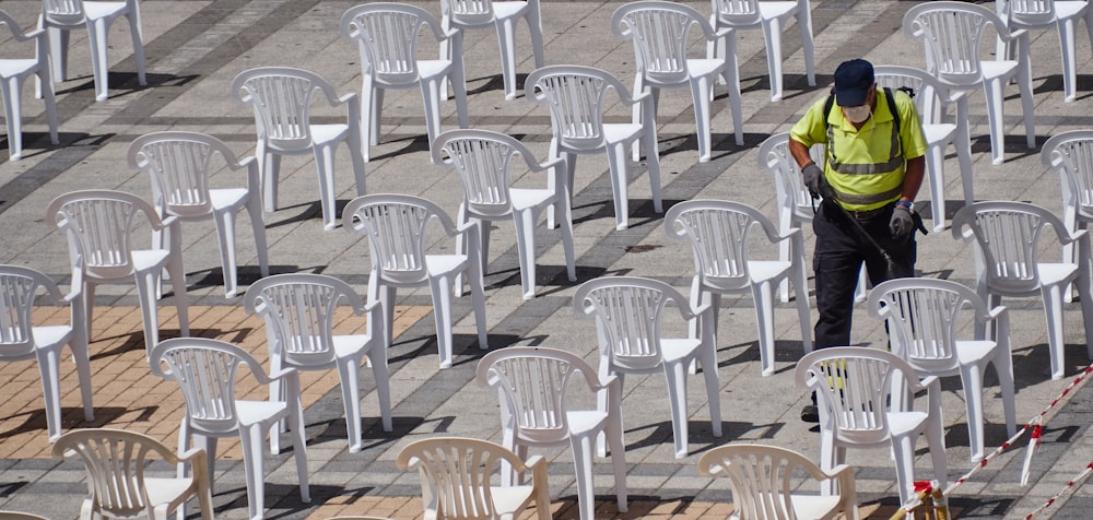 white plastic chairs on white sand during daytime