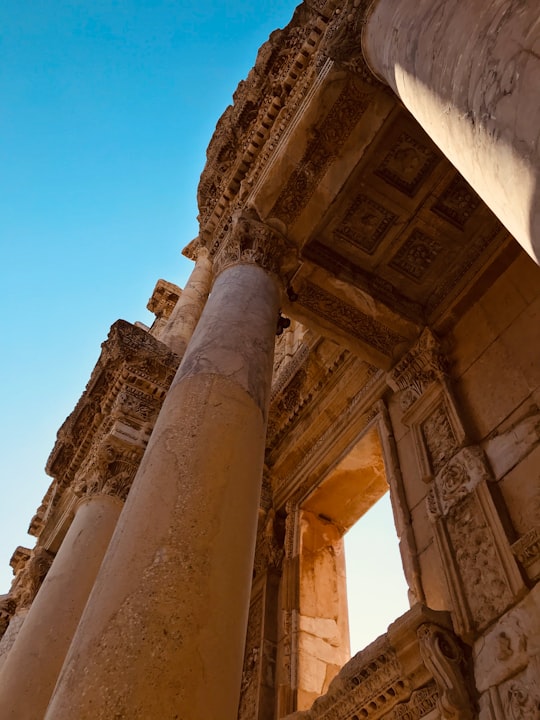 low angle photography of brown concrete building under blue sky during daytime in Efes Antik Kenti Turkey