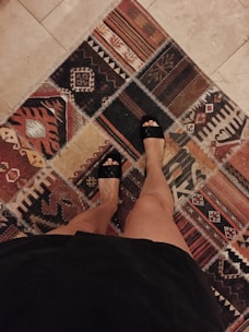 A soft decorative throw rug laid out on a wooden floor, inviting bare feet to step in.