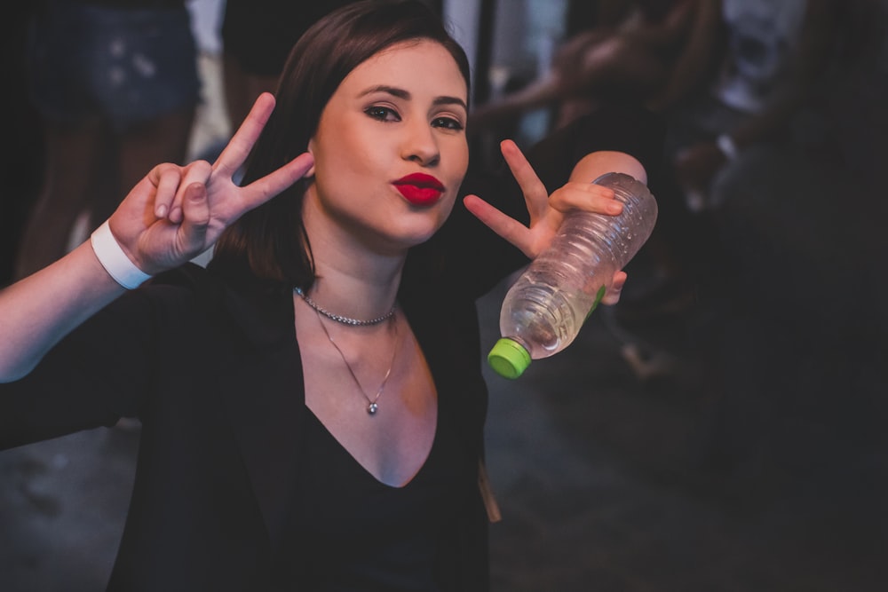 woman in black scoop neck shirt holding bottled water