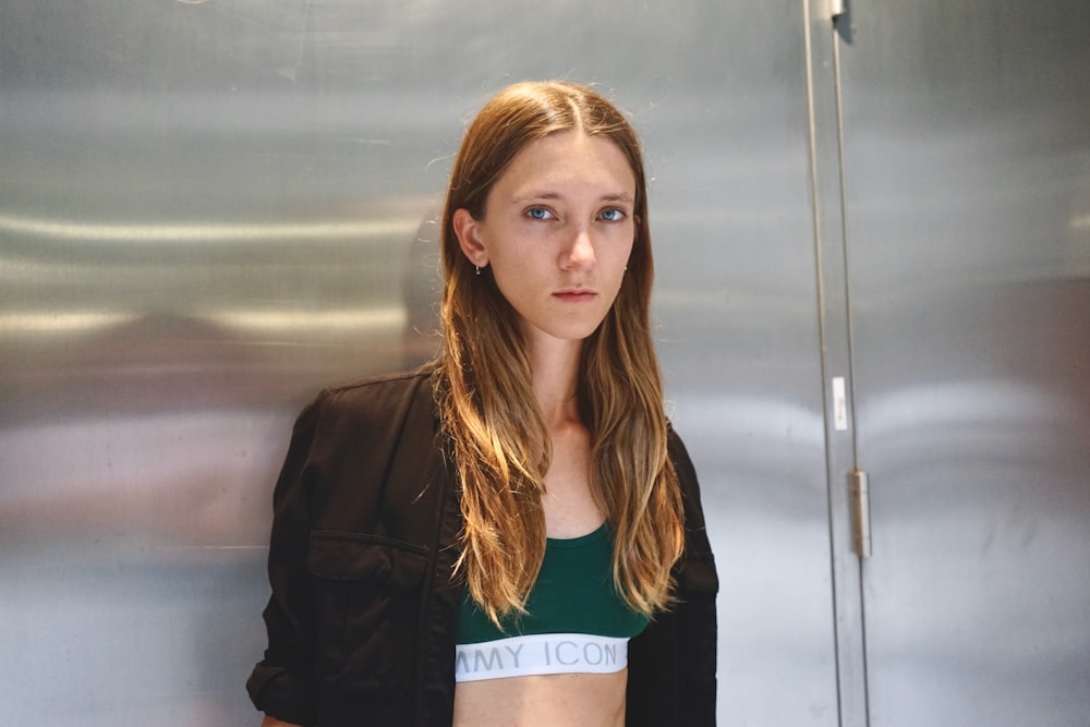 a woman standing in front of a metal wall