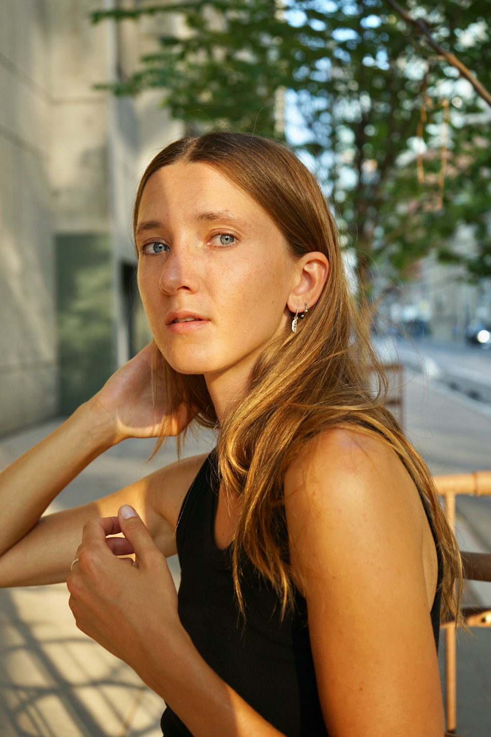 a woman in a black top leaning against a wall