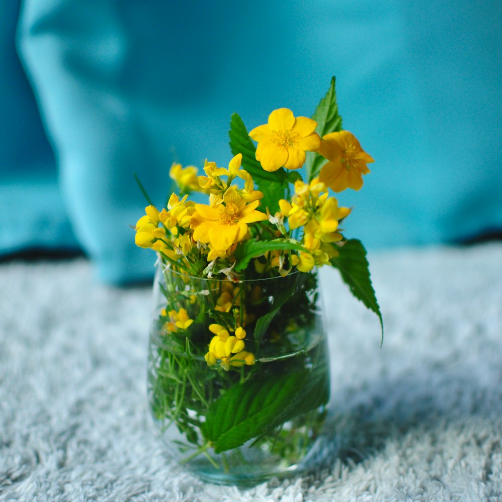 a vase filled with yellow flowers on top of a table