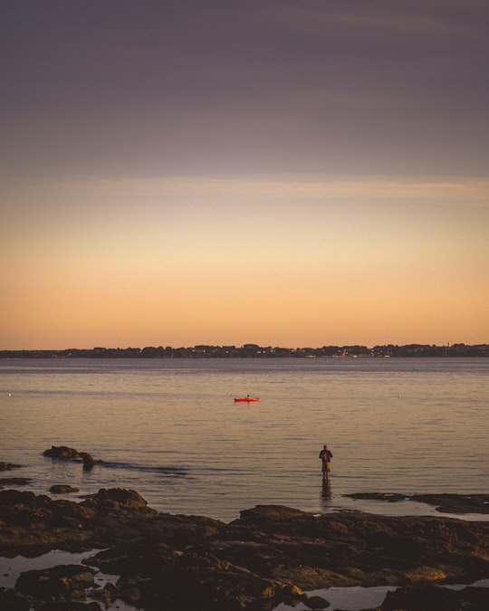 silhouette of person standing on rock near sea during sunset in Bretagne France