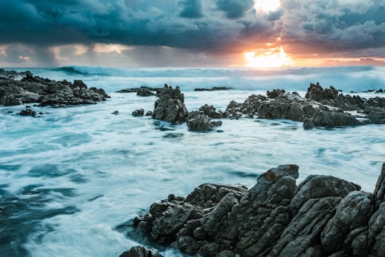 rocky shore with ocean waves during sunset in Gansbaai South Africa