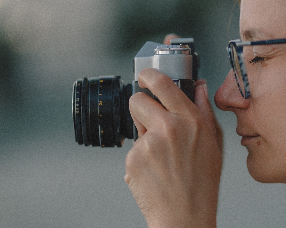 person holding black and silver camera