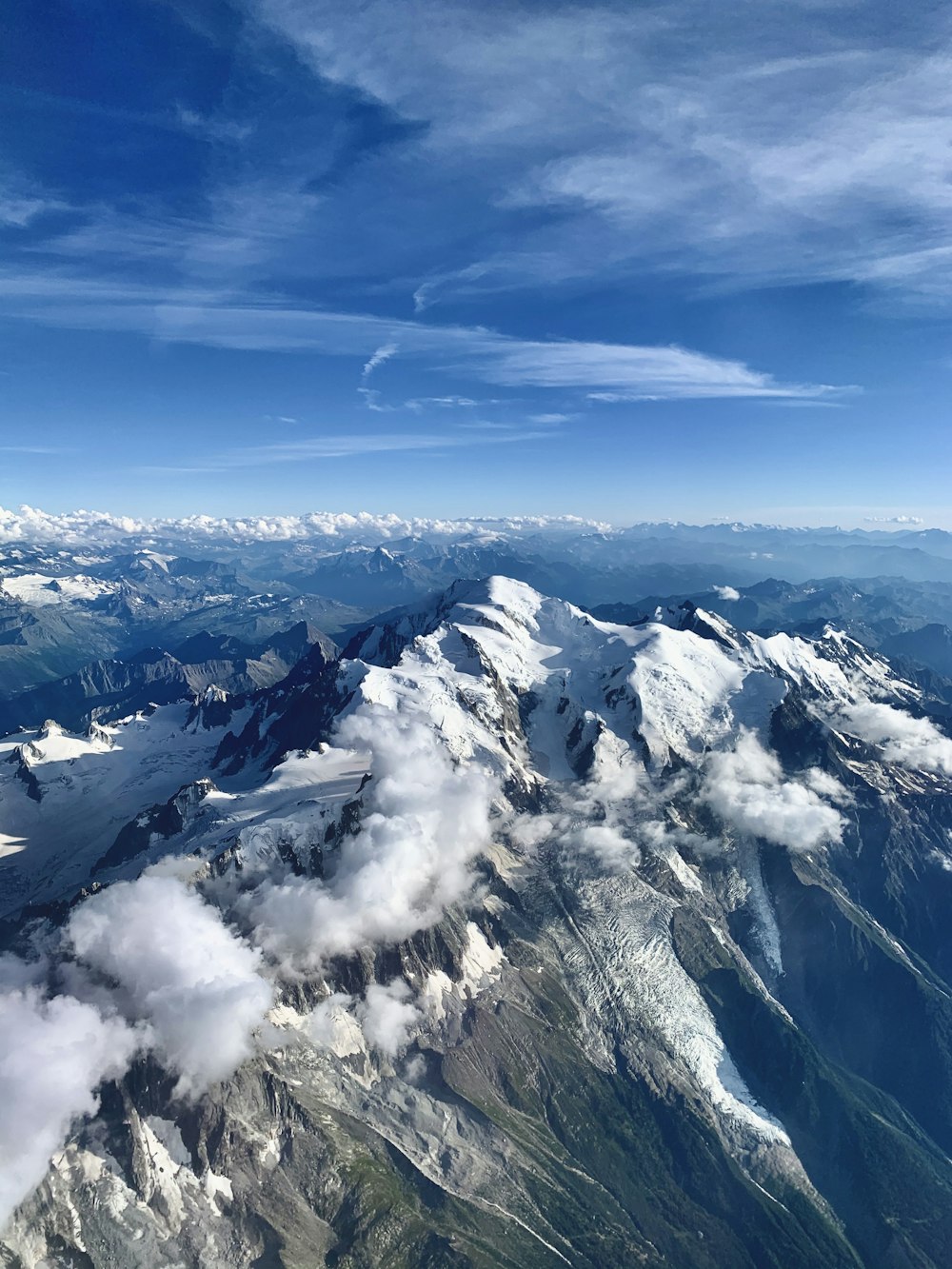 white clouds over snow covered mountains during daytime