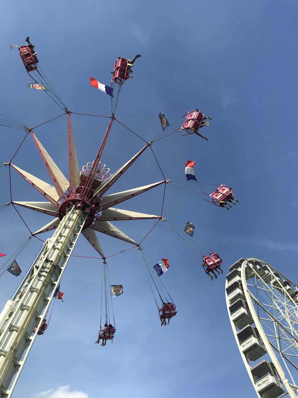 people riding on white and red ferris wheel during daytime