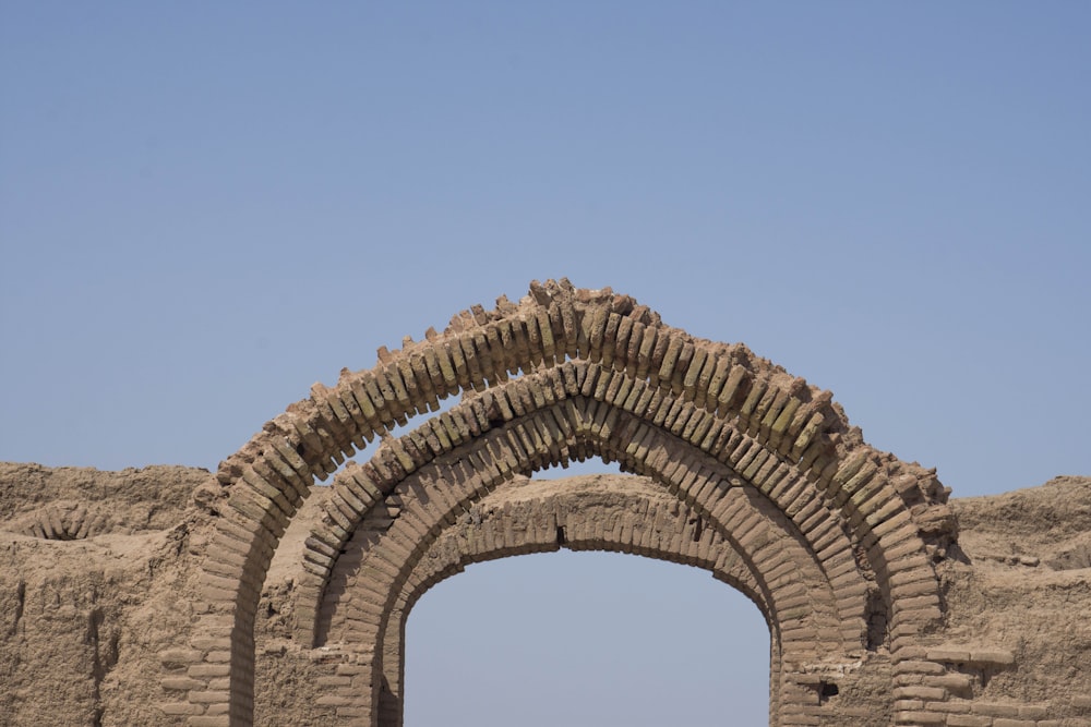 brown brick arch under blue sky during daytime