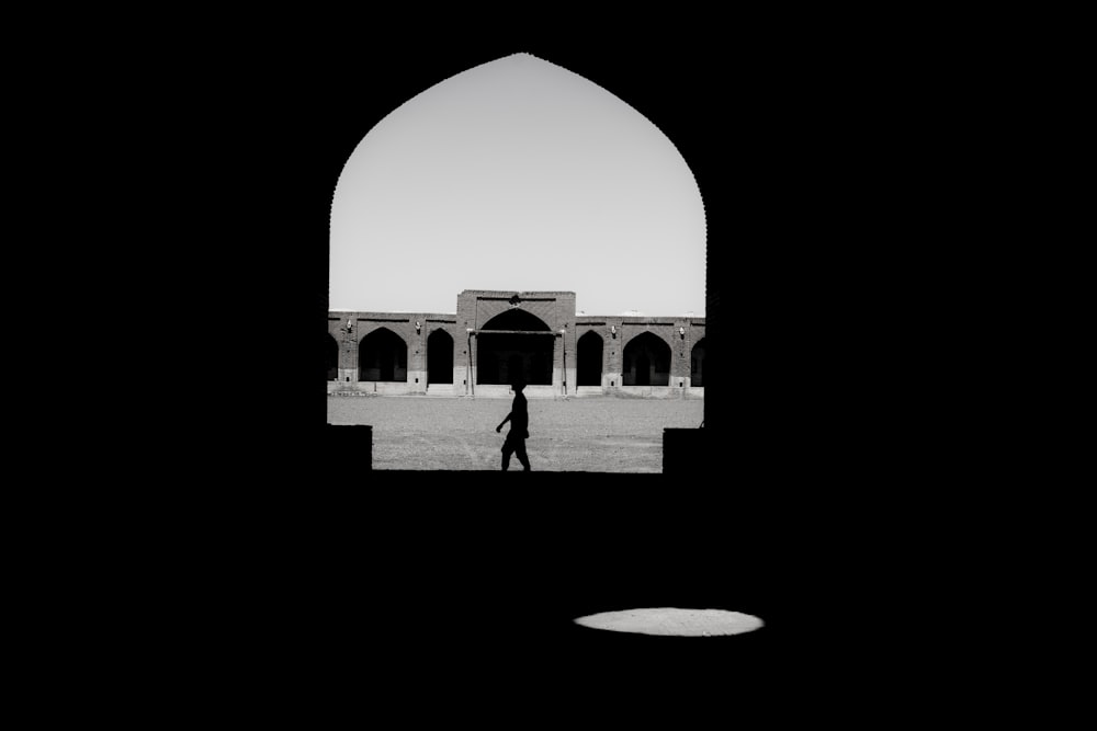 man in black jacket standing in front of white dome building