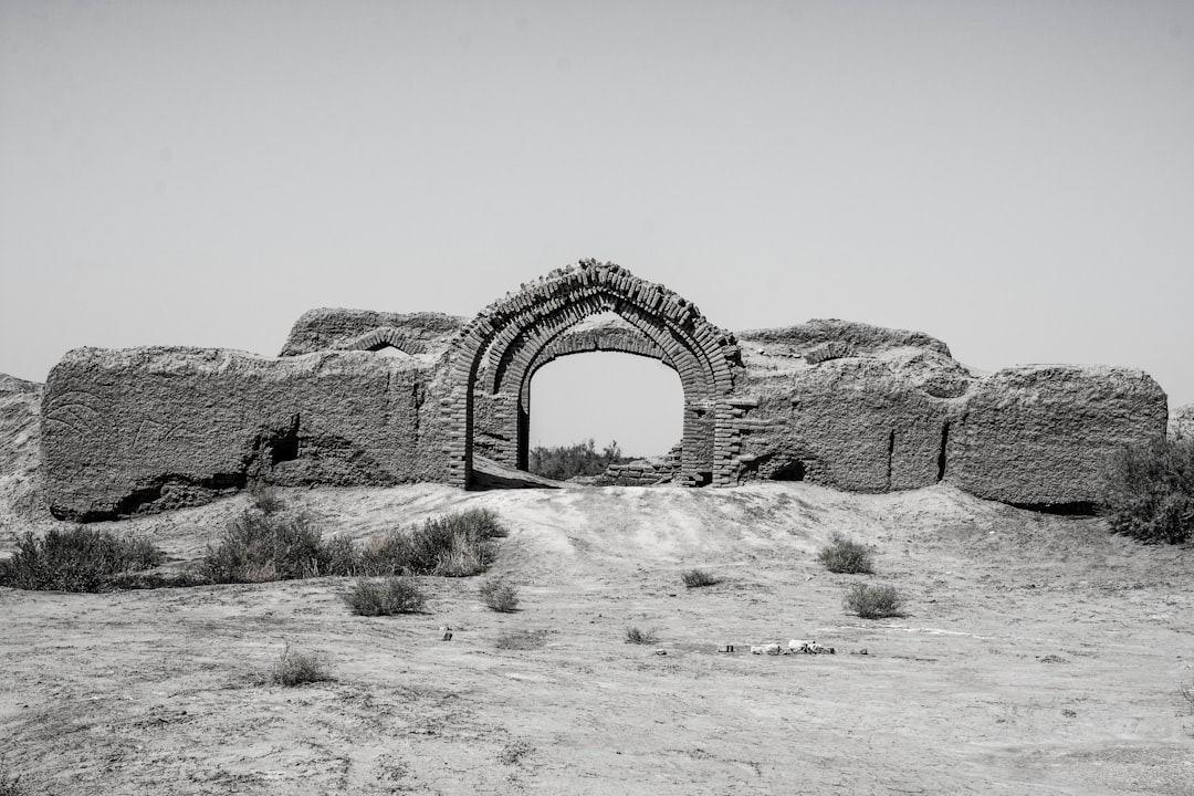 brown concrete arch on brown field during daytime