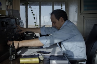 man in blue dress shirt sitting on chair