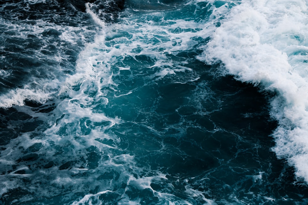 water waves hitting rocks during daytime