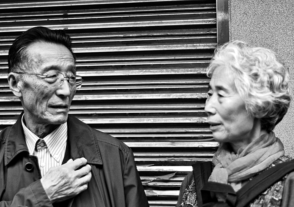 man in black suit jacket beside woman in black coat