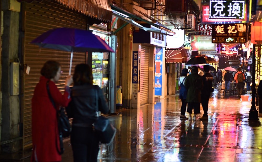 people walking on sidewalk during night time