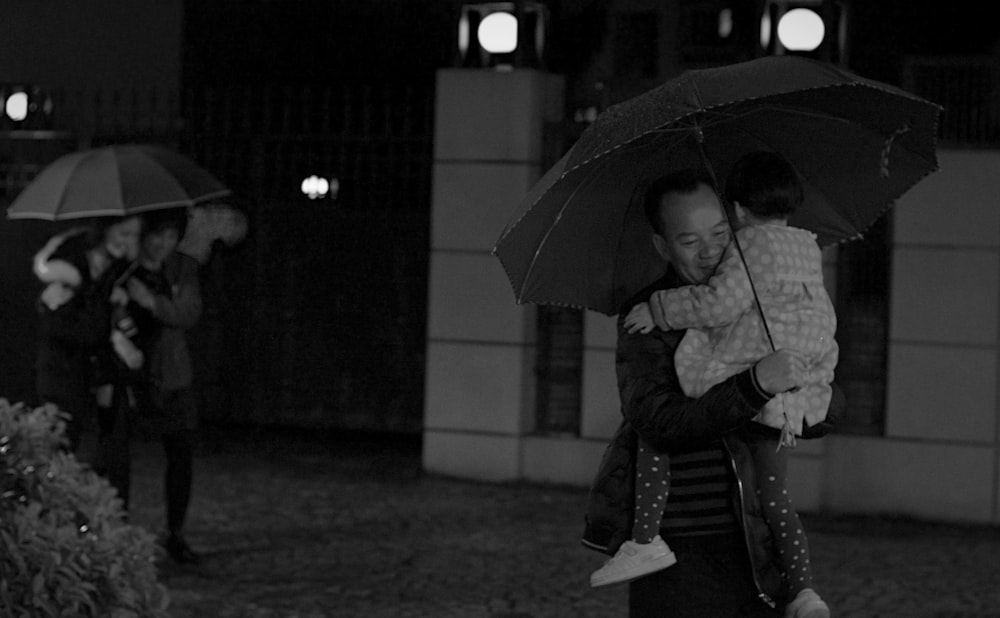 grayscale photo of woman holding umbrella