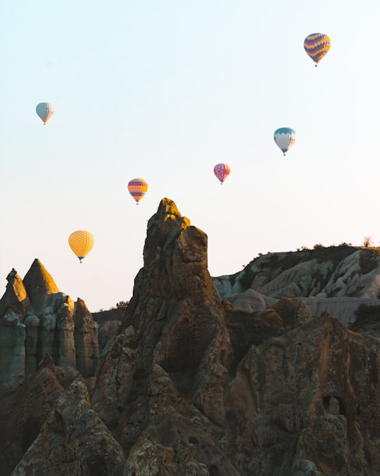 hot air balloons on air near rocky mountain during daytime in Kapadokya Turkey
