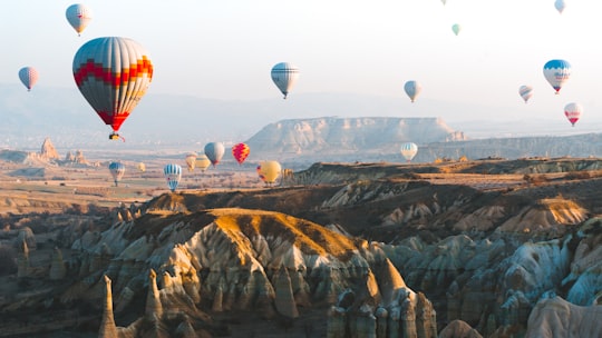 hot air balloons over the city during daytime in Kapadokya Turkey