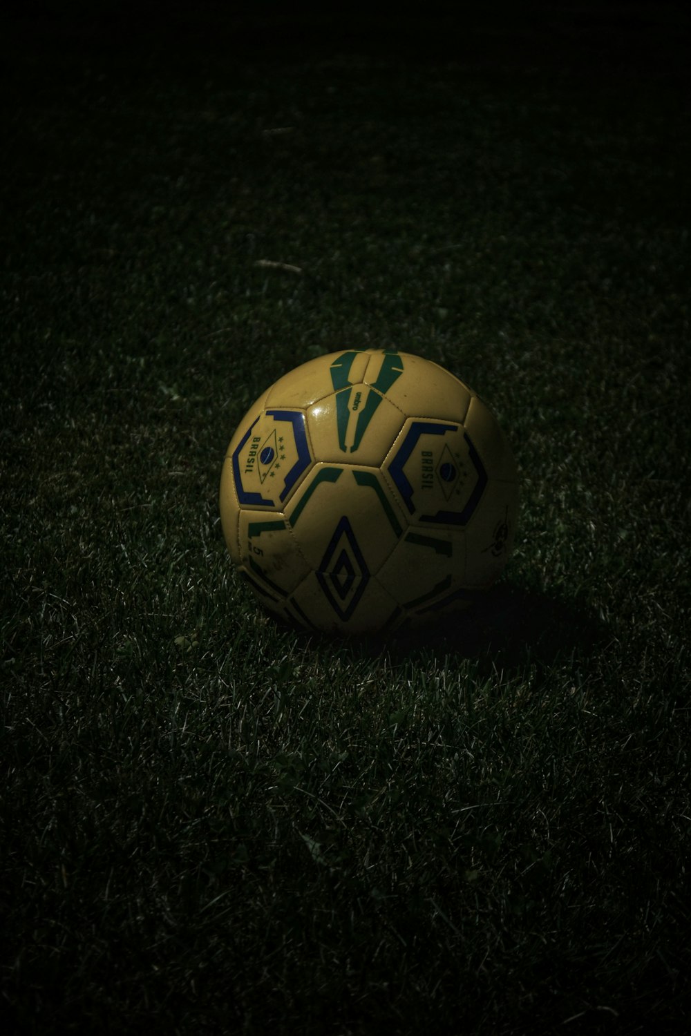 yellow and black soccer ball on green grass