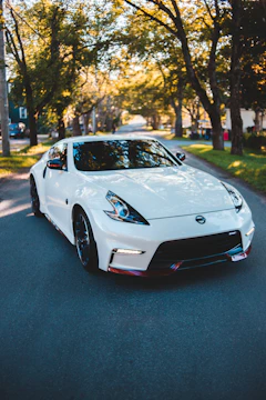 A sleek car parked safely on a suburban street under soft sunlight.
