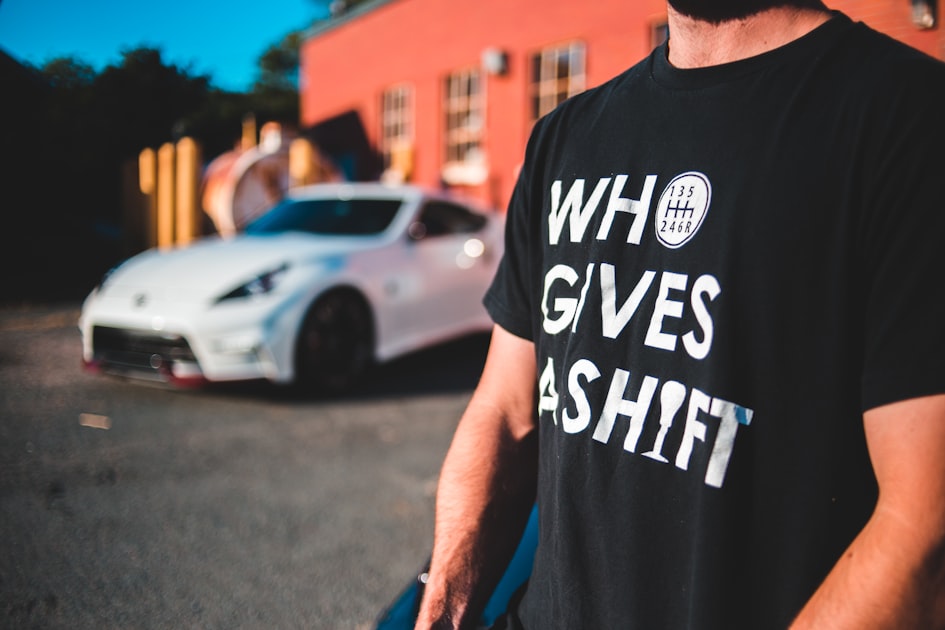 man in black crew neck t-shirt standing on road during daytime