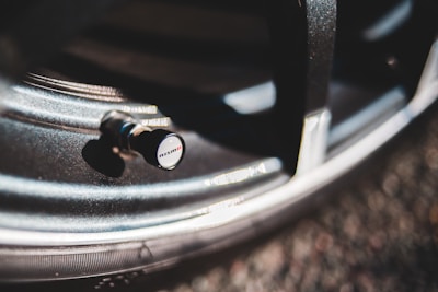 Close-up of a sleek Nissan car tire with a branded Autofit Accesorios valve cap.