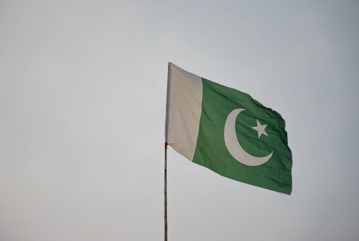 Green and white Pakistan flag against the sky