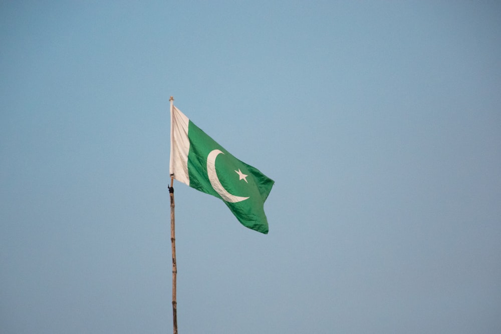 Bandera verde en el mástil bajo el cielo azul durante el día