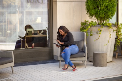 A confident business owner smiling while checking positive online reviews on a tablet.
