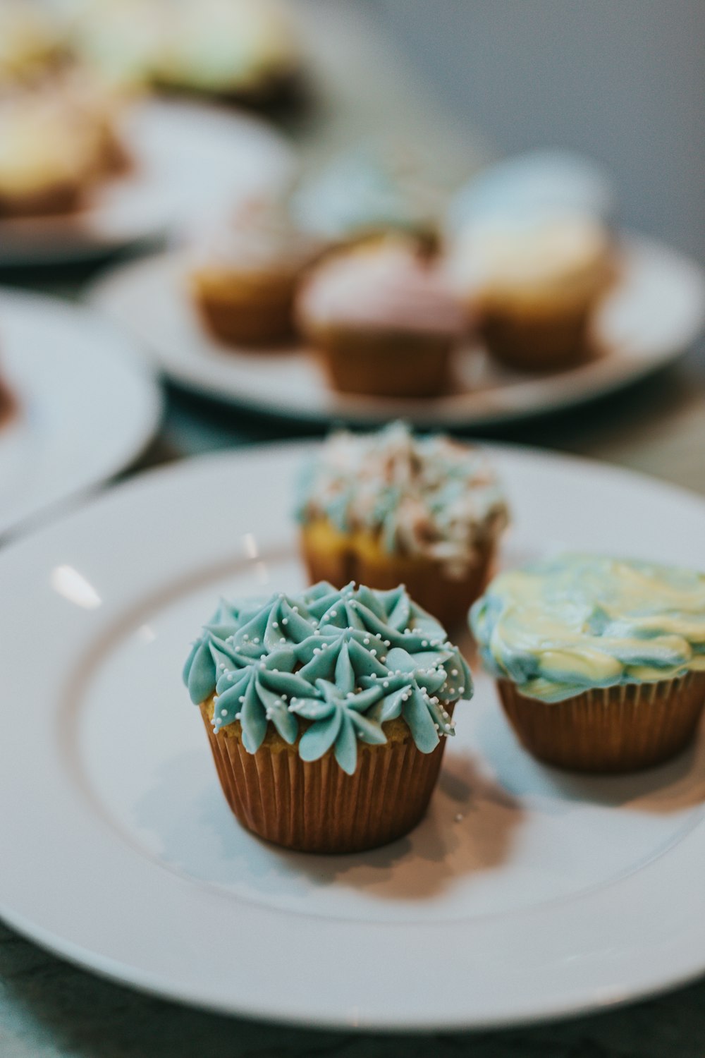 brown cupcake with white icing on white ceramic plate