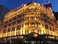 An upscale exterior facade glowing softly under premium gold-accented lighting against a deep navy night sky.