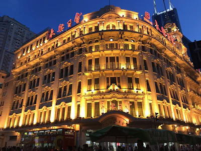 An upscale exterior facade glowing softly under premium gold-accented lighting against a deep navy night sky.