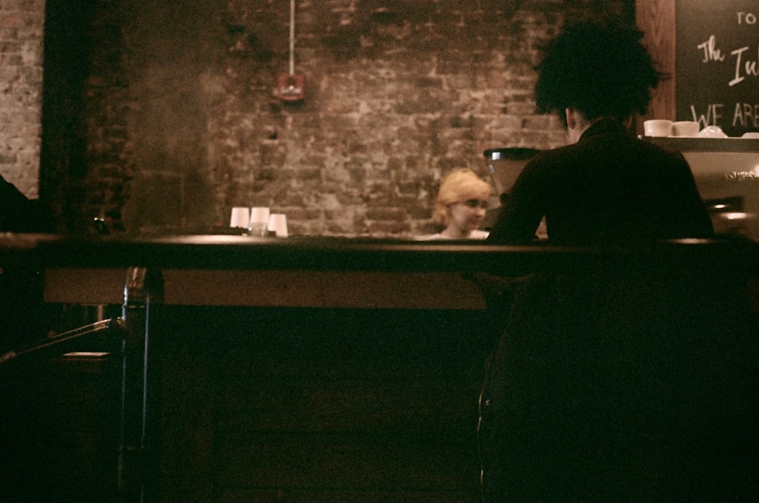 man in black shirt sitting beside table