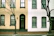 Before-and-after shot of a refreshed townhouse exterior with vibrant new paint.