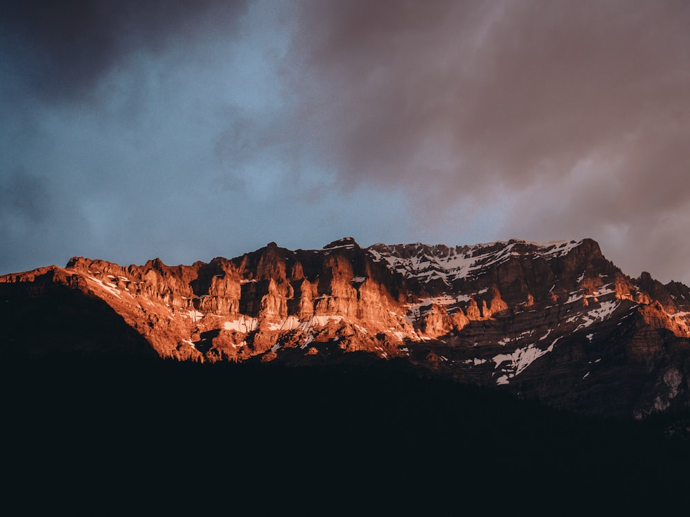 brown rocky mountain under cloudy sky during daytime