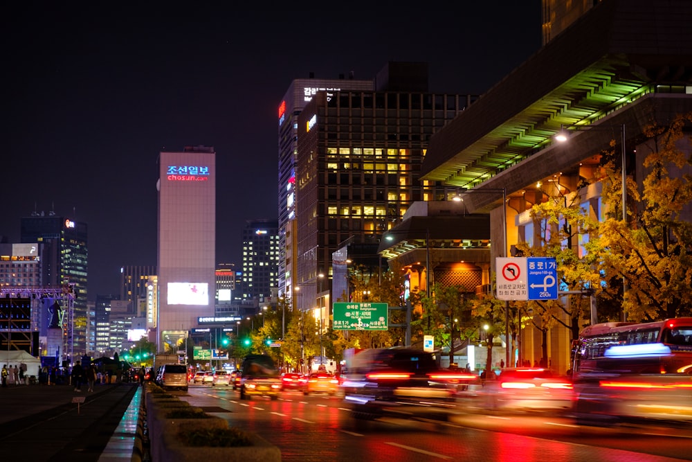 cars on road near high rise buildings during night time