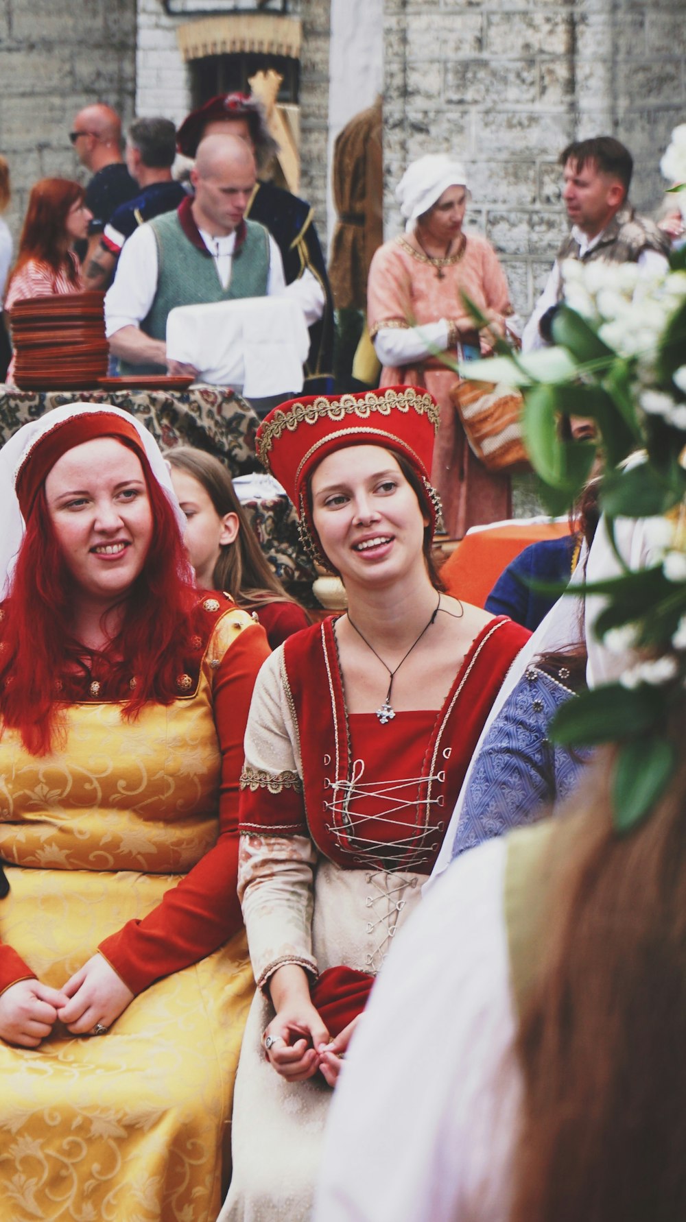 woman in red and white long sleeve shirt beside woman in red and white hat