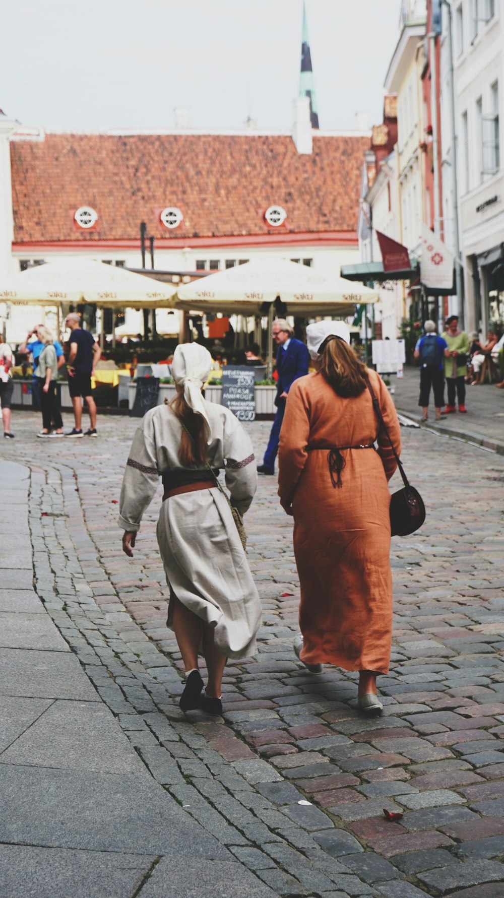 woman in red dress walking on sidewalk during daytime