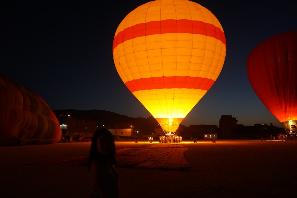 people standing near yellow red and blue hot air balloon during night time