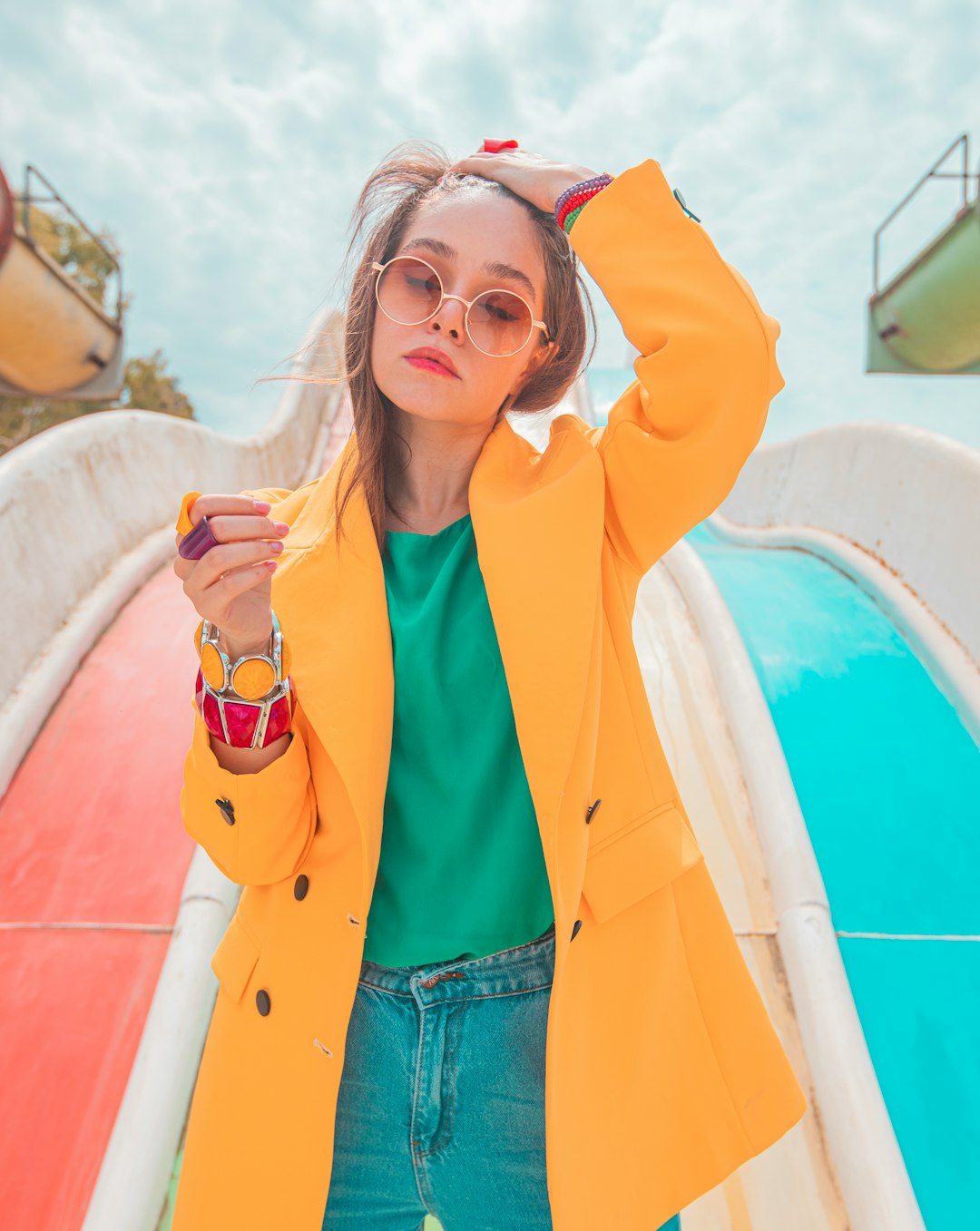 woman in yellow jacket and blue denim shorts holding white and red ceramic mug