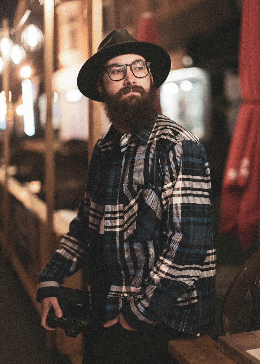 man in black and white plaid dress shirt wearing black fedora hat