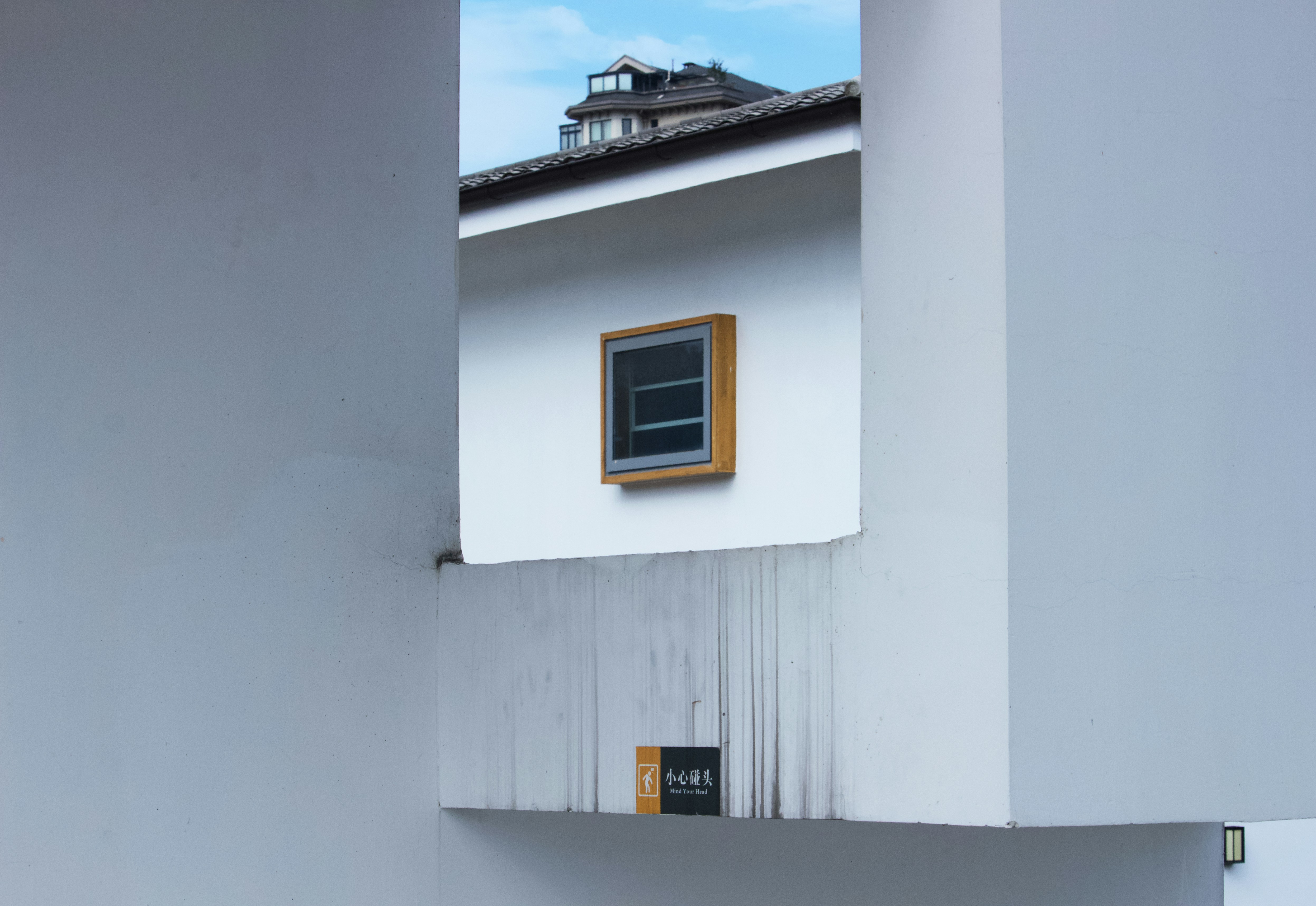 white concrete building with yellow window