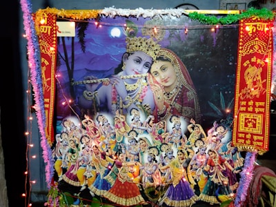 A vibrant and colorful scene depicting Hindu deities adorned with intricate costumes and jewelry, surrounded by an array of smaller figures engaged in dance and music. The setting includes decorative elements like garlands, lights, and traditional motifs.