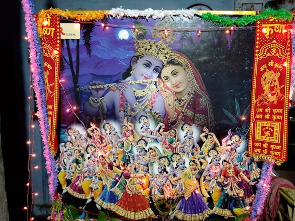 A vibrant and colorful scene depicting Hindu deities adorned with intricate costumes and jewelry, surrounded by an array of smaller figures engaged in dance and music. The setting includes decorative elements like garlands, lights, and traditional motifs.