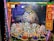 A vibrant and colorful scene depicting Hindu deities adorned with intricate costumes and jewelry, surrounded by an array of smaller figures engaged in dance and music. The setting includes decorative elements like garlands, lights, and traditional motifs.
