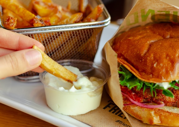 burger with cheese and vegetable on stainless steel tray